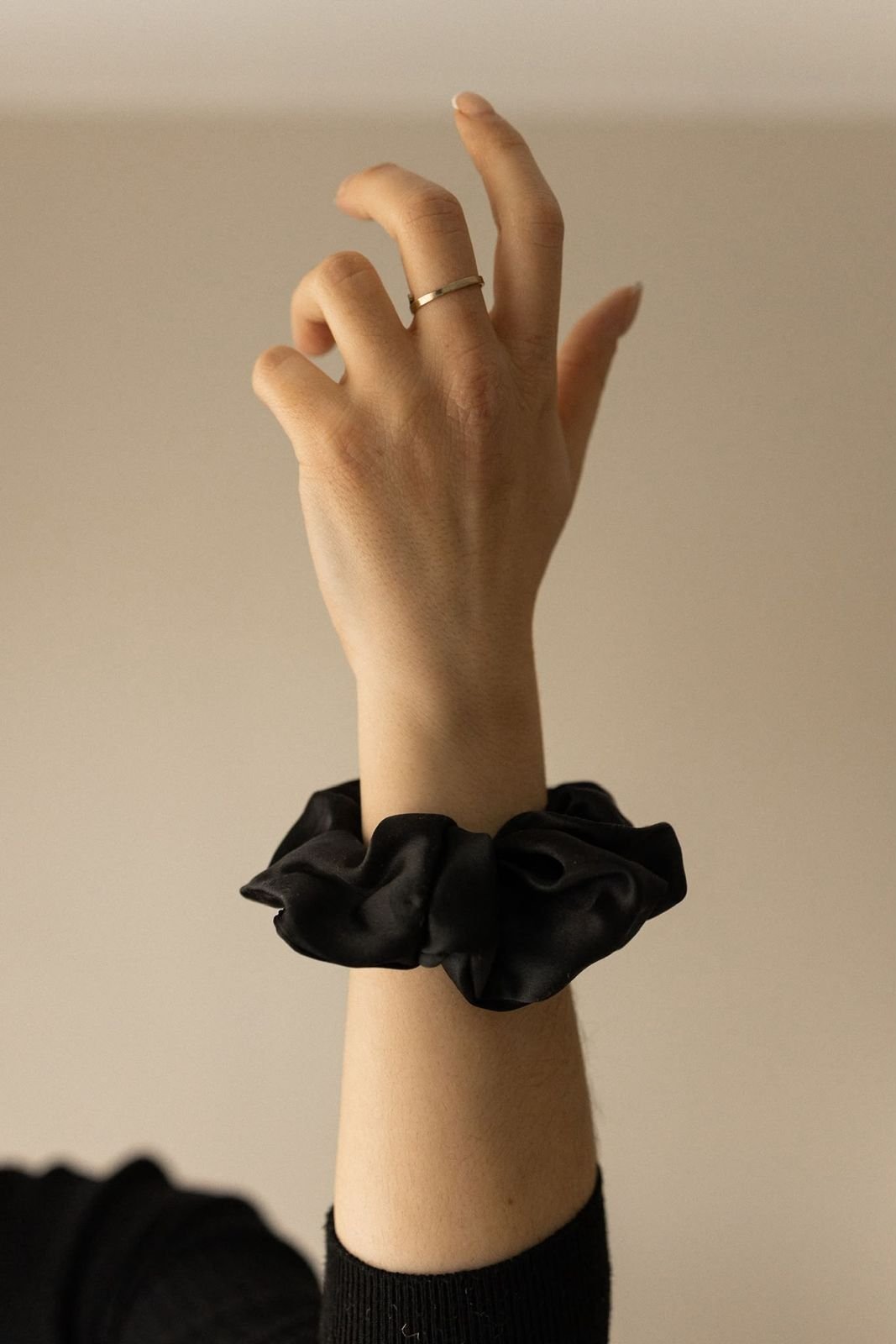 Bras levé portant un chouchou en satin de soie noir